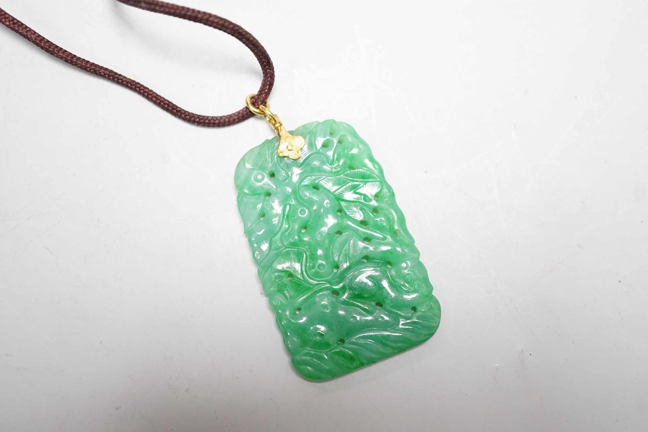 A carved Chinese jadeite pendant with pierced decoration. 5.5 x 3cm